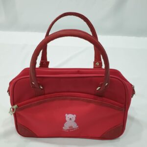 The handbag has an inner pocket with side pockets and 1 front pocket with zip.
